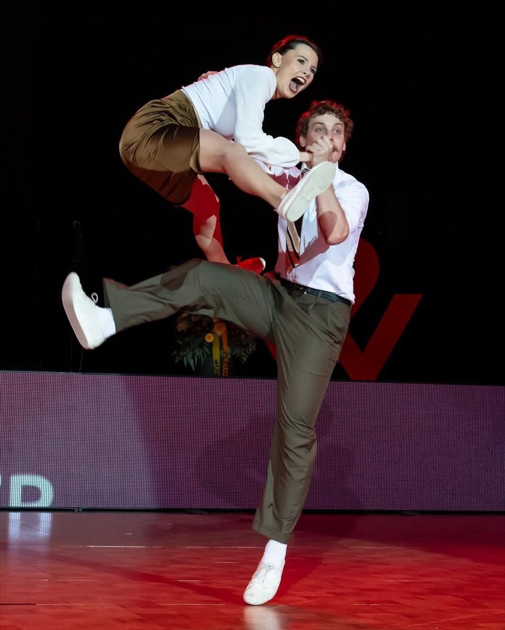 Couple de Boogie Woogie en plein saut, grand sourire